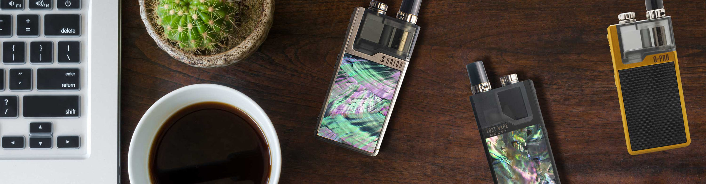 Lost Vape vaporizers laying down on dark wooden office table inside home.